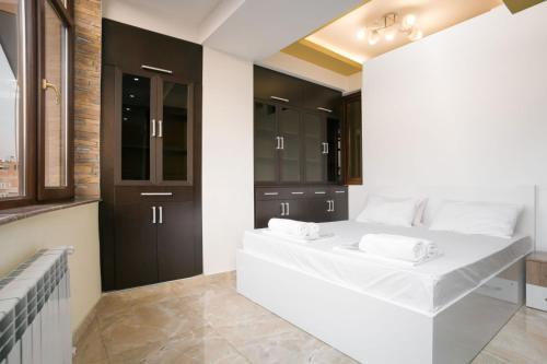 a bedroom with a white bed and black cabinets at Stylish 2 Bedroom! Heart of city!! in Yerevan
