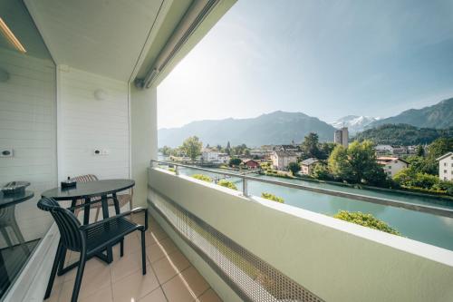 a balcony with a table and chairs and a view at HOP Apartments & Suites in Interlaken