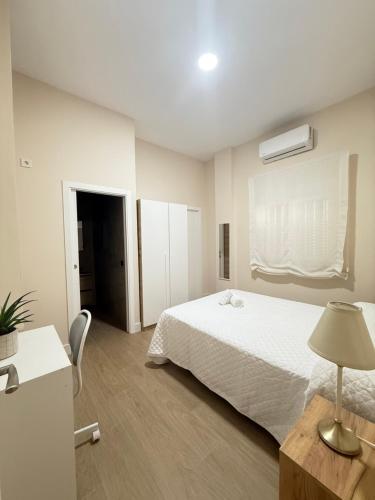 een slaapkamer met een bed en een tafel met een lamp bij Apartamento Orilla de Triana Luxury in Sevilla