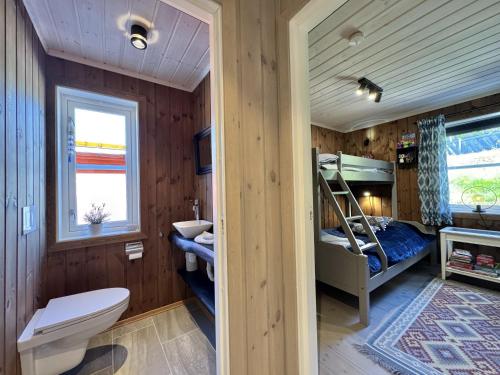 a bathroom with a bed and a toilet in a room at Bjørnebo, Family cabin in Torpo