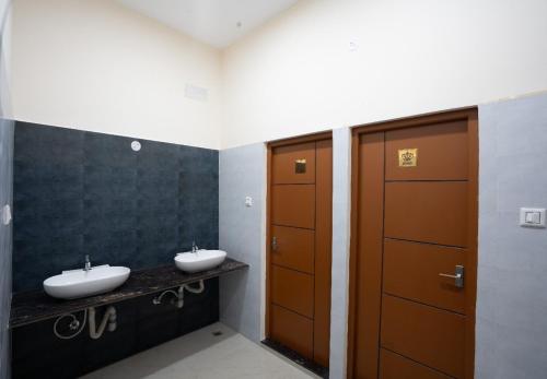 a bathroom with two sinks and a door at MSB Silver Spring Resort in Yelagiri