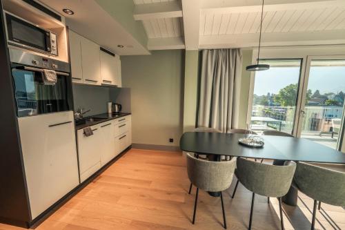 a kitchen with a table and chairs in a kitchen at HOP Apartments & Suites in Interlaken