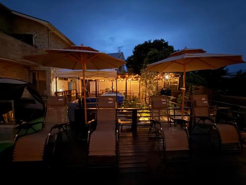 a patio with chairs and umbrellas at night at リゾートヴィラ宮島 Sunset terrace in Hatsukaichi