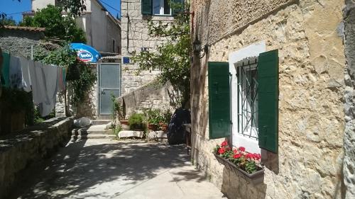eine Gasse in einem Dorf mit grüner Tür und Blumen in der Unterkunft Karmen's Apartment One in Split