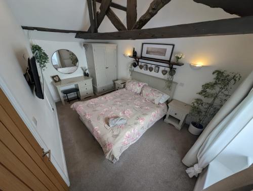 een kleine slaapkamer met een bed en een spiegel bij Hocking Cottage in Torquay