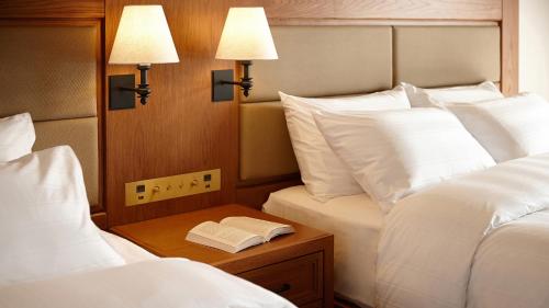 a bedroom with two beds and a book on a table at Lotte Arai Resort in Myoko