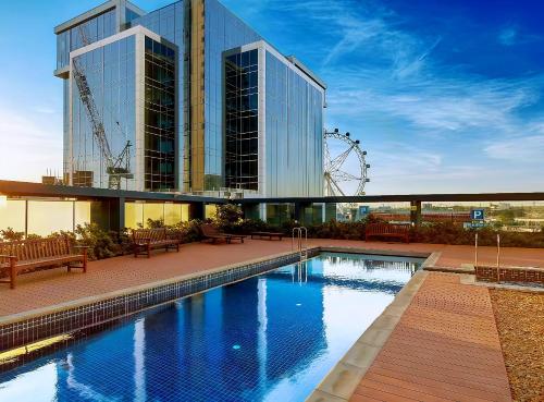 a hotel with a swimming pool in front of a building at Aerie Stays NewQuay Collection in Melbourne