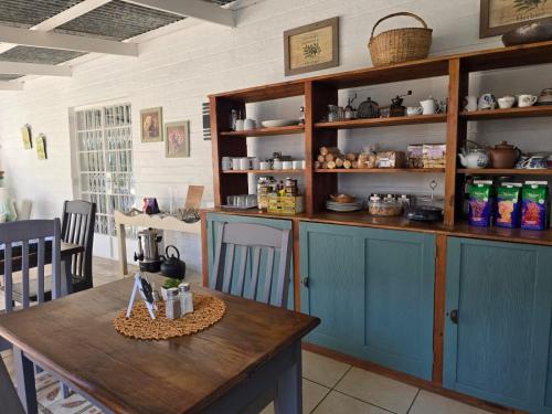 a kitchen with blue cabinets and a wooden table at Dogwood Country House in Lidgetton