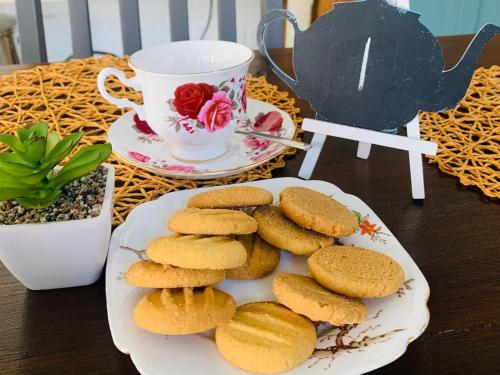 a plate of biscuits on a table with a cup of tea at Dogwood Country House in Lidgetton