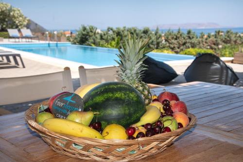 - une corbeille de fruits sur une table près de la piscine dans l'établissement Four Seasons private villa - seaview - big heated pool - gym - sport activities, à Gouves