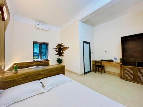 a bedroom with a large bed and a desk at Hoa Lu Garden Resort in Ninh Binh