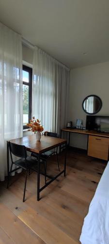 a living room with a table and a room with a bed at Chalet Lago in Taverna