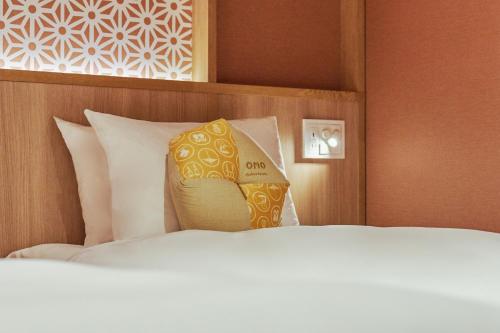 a hotel room with a bed with a yellow pillow at OMO5 Kyoto Gion by Hoshino Resorts in Kyoto