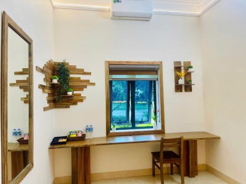 a room with a table and a window and a mirror at Hoa Lu Garden Resort in Ninh Binh
