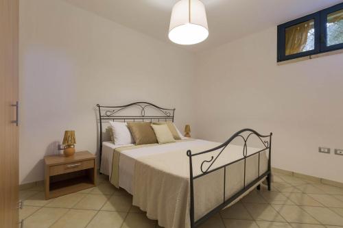 a bedroom with a bed and a table and a lamp at Tenuta Gianfredi by BarbarHouse in Casarano
