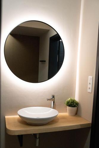 a bathroom with a white sink and a mirror at Camping Natuurlijk Limburg - Appartement in Voeren