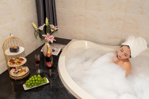 a woman is laying in a bath tub at Grand Fusion Point Hotel in Hue