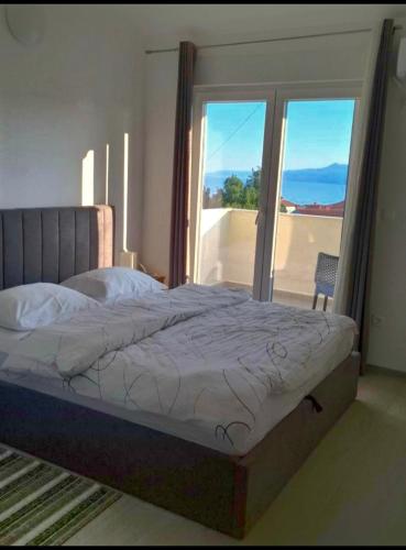 a bedroom with a bed with a view of a balcony at Apartment Tanya in Rijeka