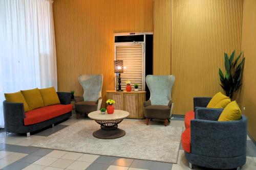 a living room with couches and a table and chairs at Kuala Melaka Inn in Pantai Cenang