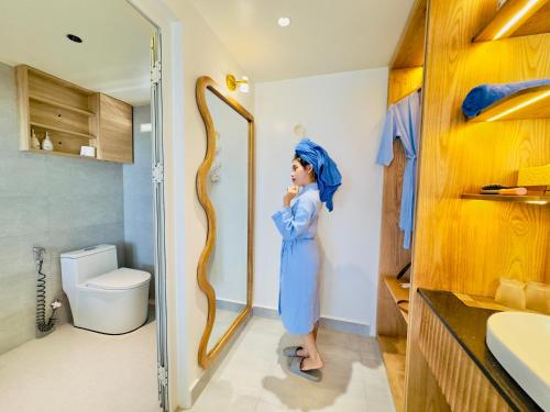 a woman standing in a bathroom with a mirror at Villa Đại Dương View Biển Đảo Phú Quý in Cu Lao Thu