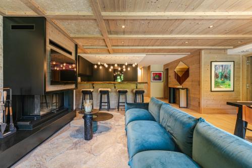 Rochebrune - Appartement de luxe في ميجيف: غرفة معيشة مع أريكة زرقاء وبار