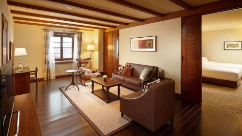 a living room with a couch and a bed at Lotte Arai Resort in Myoko