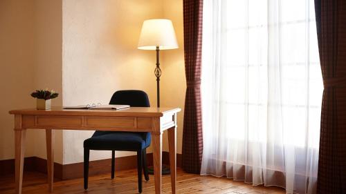 a desk with a lamp and a chair next to a window at Lotte Arai Resort in Myoko
