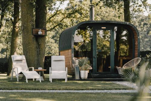 a group of chairs and a table in the grass at Maison Idyllique in Bree