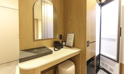 a bathroom with a desk with a phone and a mirror at Yeongju Browndot Yeongju Jungang Branch in Yongju