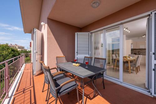 a patio with a table and chairs on a balcony at Apartment Rubina, 2 bedrooms, big terrace and secure parking in Medulin