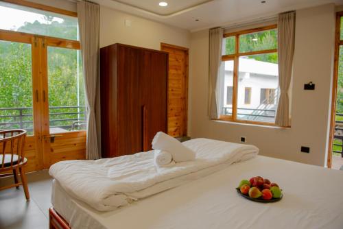 a bedroom with a bed with a bowl of fruit on it at sharan stay in Nagar