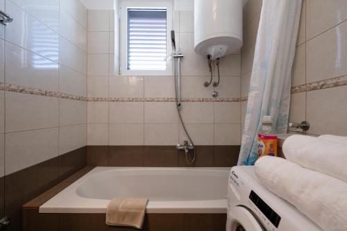 a bathroom with a bath tub and a window at Apartment Rubina, 2 bedrooms, big terrace and secure parking in Medulin