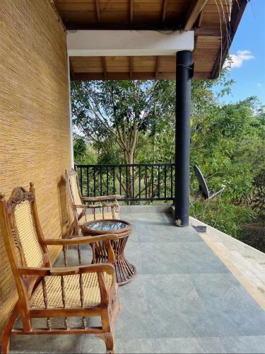a porch with two chairs and a table at Nature's Hideaway in Anuradhapura