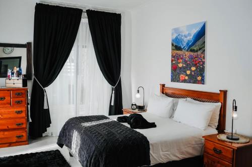 a bedroom with a bed with a black dog laying on it at Calabash Cape Town in Darling