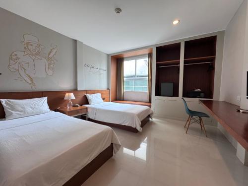 a hotel room with two beds and a television at CHERN Bangkok in Bangkok