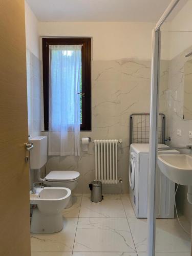 a bathroom with a toilet and a sink at Residence Borgo Castello E1 Apartment in Argegno