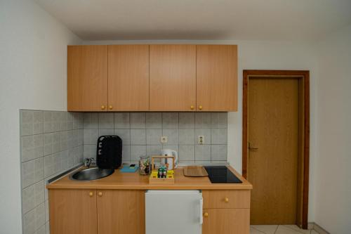 a kitchen with wooden cabinets and a sink at Villa Green Mak in Neum
