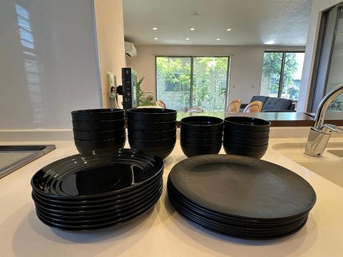 a pile of black plates sitting on a kitchen counter at リゾートヴィラ宮島 Sunset terrace in Hatsukaichi