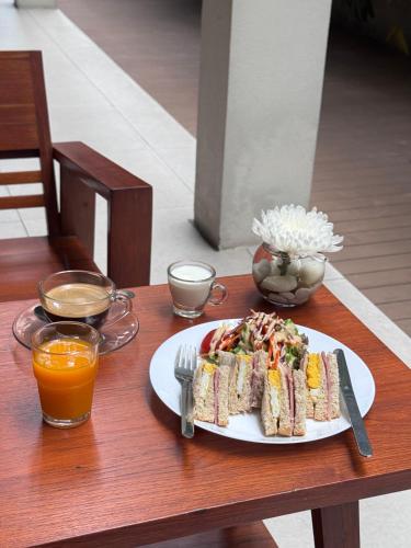 a plate of sandwiches on a table with orange juice at CHERN Bangkok in Bangkok