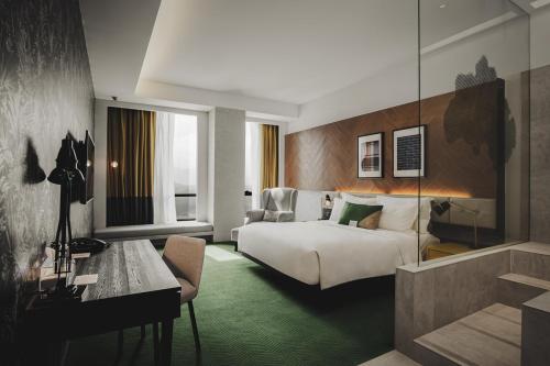 a hotel room with a bed and a desk at WEIL Hotel Ipoh in Ipoh