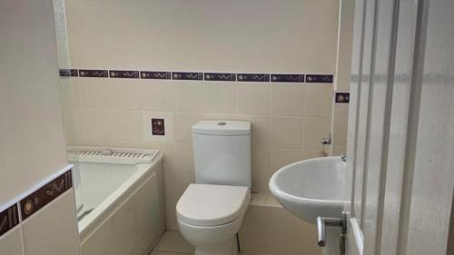a bathroom with a toilet and a tub and a sink at 3 Bedroom Home, Walk to Town in Cobh