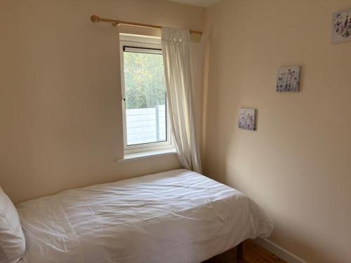 a small bedroom with a bed and a window at 3 Bedroom Home, Walk to Town in Cobh