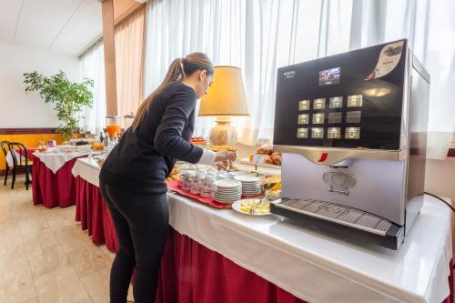 a woman is preparing food at a buffet at Ilgo Hotel in Perugia