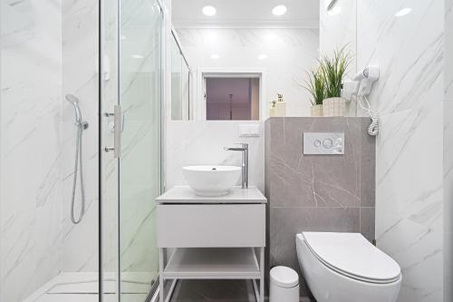 a bathroom with a toilet and a sink and a shower at Golden Apartments - Mennica Residence Luxury Stay in Warsaw