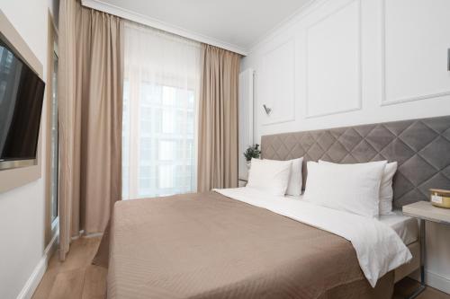 a bedroom with a large bed and a large window at Golden Apartments - Mennica Residence Luxury Stay in Warsaw