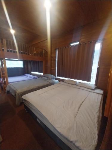 two beds in a room with two windows at Varvara hill in Cigugur