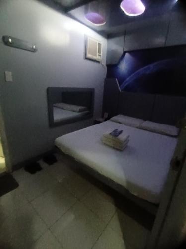 a small room with a bed with purple lights at Astrotel Calamba in Calamba