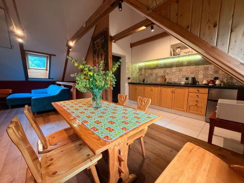 a kitchen with a wooden table with a vase of flowers on it at Chatka Trapera in Bielice