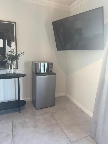 a living room with a large television and a table at Kénōsis Guestfarm- Two Bedroom Apartment in Springbok