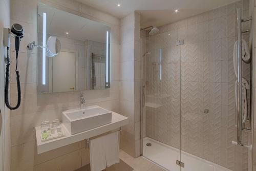 a bathroom with a sink and a shower at NH Bologna De La Gare in Bologna